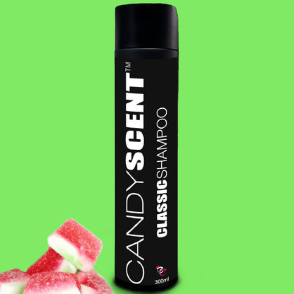 A black rectangular bottle of CANDYSCENT™ Classic Shampoo stands upright on a vibrant green background. In the foreground, several pink and white candy pieces are piled at the bottom left corner. The 300ml bottle promises a luxurious shampoo experience for your hair care routine.