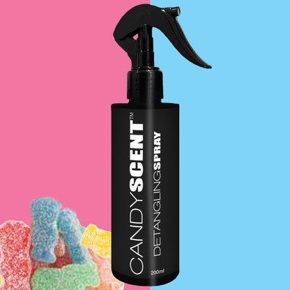 A black spray bottle labeled "CANDYSCENT™ Hair Detangling Spray 200ml" is set against a vibrant background with pink on the left and blue on the right. Infused with Aloe Vera and Jojoba Oil, this luxurious spray promises smooth locks. In the bottom left corner, colorful gummy candies complete the scene.