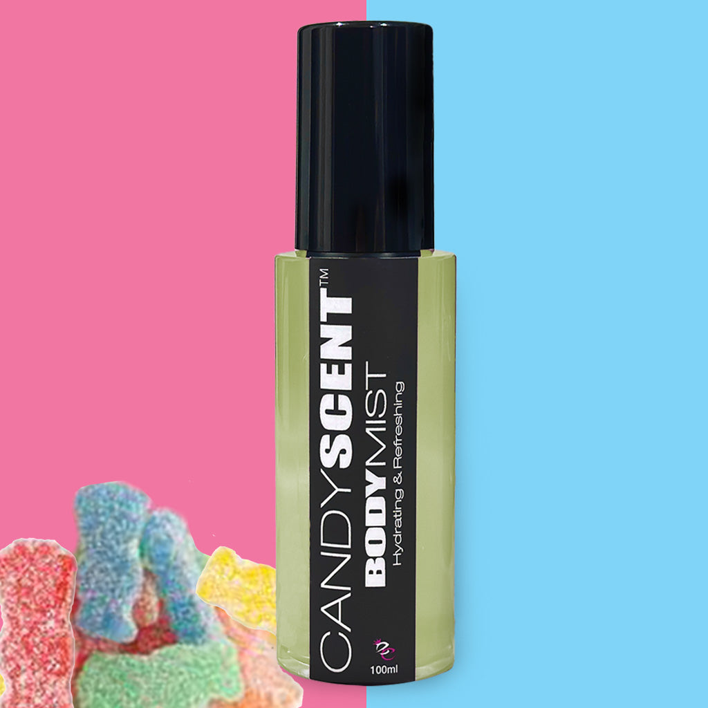 A black and yellow Hydrating Body Mist bottle labeled "CANDYSCENT™: Hydrating & Refreshing" is in the center of the image. Formulated with nourishing ingredients like witch hazel, it sits against a background split into pink on the left and blue on the right, with colorful gummy candies in the lower left corner.