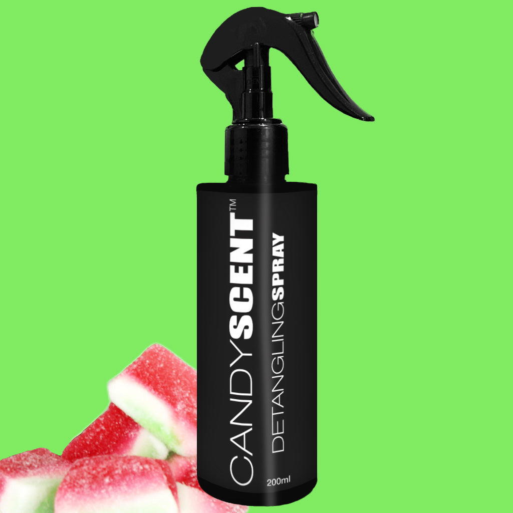 A black bottle of CANDYSCENT™ Hair Detangling Spray with aloe vera and jojoba oil sits against a bright green background. The 200ml bottle is labeled with white text, accompanied by pieces of red and white candy.