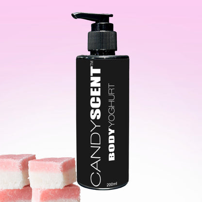 A black bottle labeled "Body Yoghurt" by CANDYSCENT™ features a pump and is set against a pink gradient background, offering deep hydration. Three pieces of pink and white candy are charmingly placed in the lower left corner, enhancing this delightful and nourishing experience.