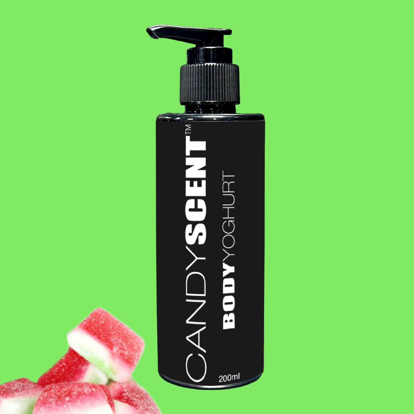 Against a vibrant green backdrop, a black bottle featuring the CANDYSCENT™ Body Yoghurt with a pump dispenser promises a nourishing experience. Small cubes of red and white candy in the bottom left corner enhance its sweet allure.