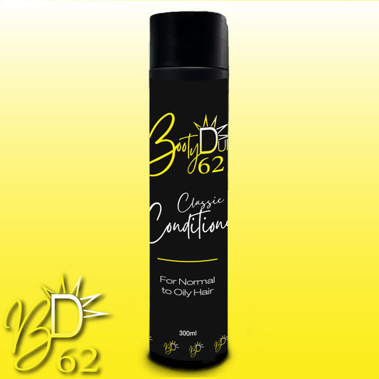 Image of a sleek black and yellow bottle labeled "Classic Conditioner" from BOOTY DUPE, formulated for normal to oily hair. This 300 ml tall bottle, featuring a black cap, is enriched with Cacay and Macadamia oil. The brand's logo, "BD 62," is prominently displayed on the label and in the bottom left corner of the image.